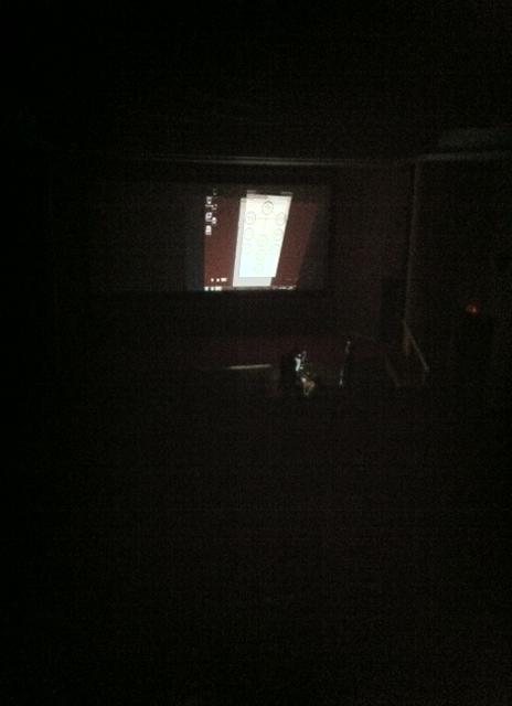 In-game pic, view of the players fiddling with the kabbalah computer in the dark movie house.